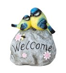Birds sitting on stone with "Welcome"
