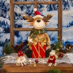 Elch mit Schal und Nikolausmütze sitzend