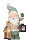 Santa with lantern in hand near reindeer