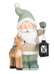 Santa with lantern in hand near reindeer